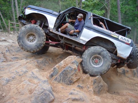 1996 Ford Bronco - This heavily modified SUV is navigating a challenging rocky terrain.