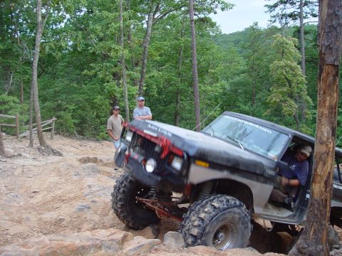 1996 Ford Bronco - Off-road vehicle tackling a challenging rocky path with spectators watching.