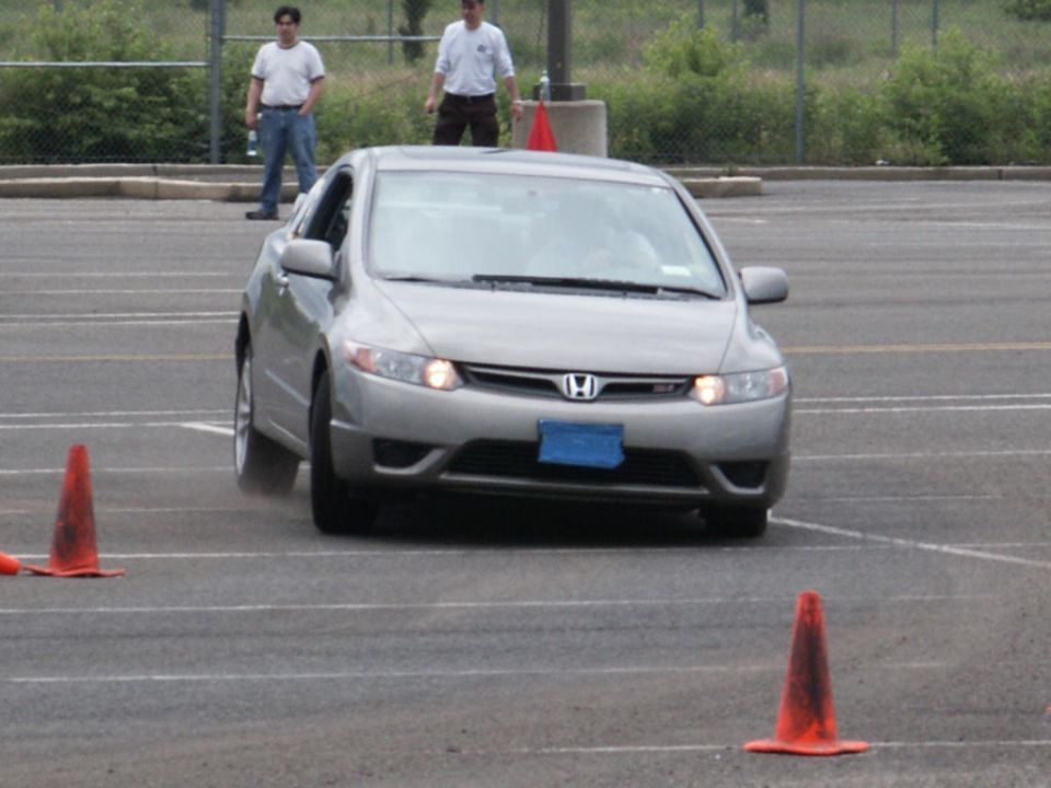 Silver Honda Civic driving on a track with orange cones