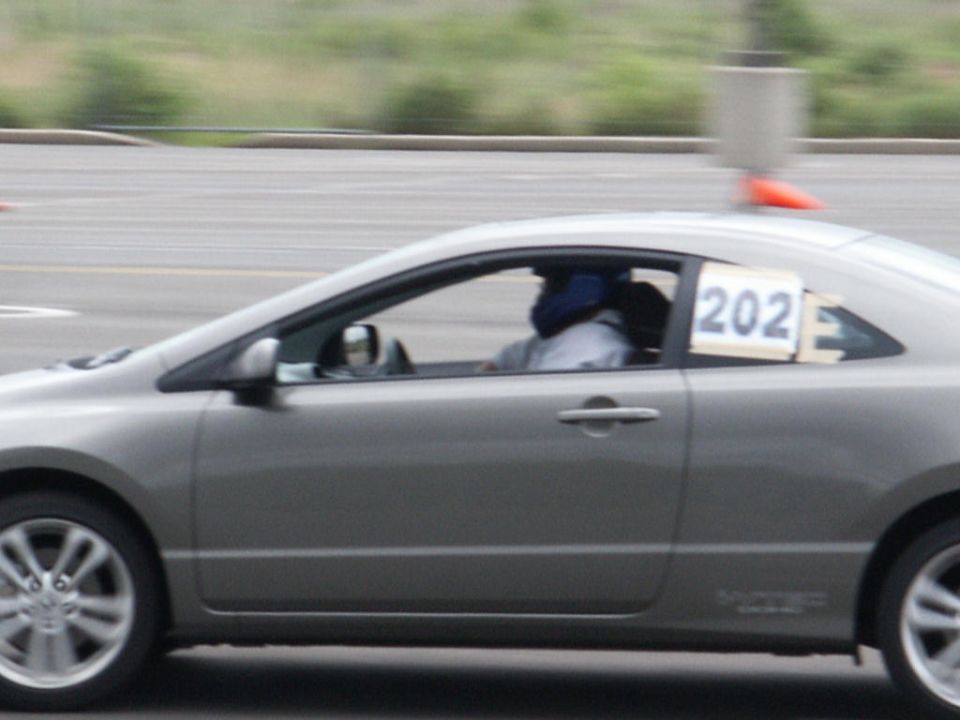 Gray coupe side view with racing number 202 on rear window
