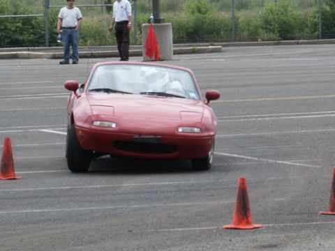 2001 Mercury Grand Marquis - Red Mazda Miata with pop-up headlights navigates a course marked by orange traffic cones.