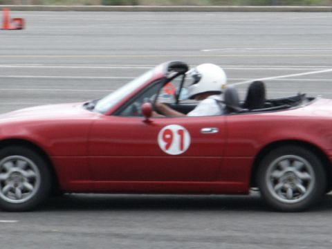 2001 Mercury Grand Marquis - A red convertible with racing number 91 is driven by a person in a white helmet on a track.