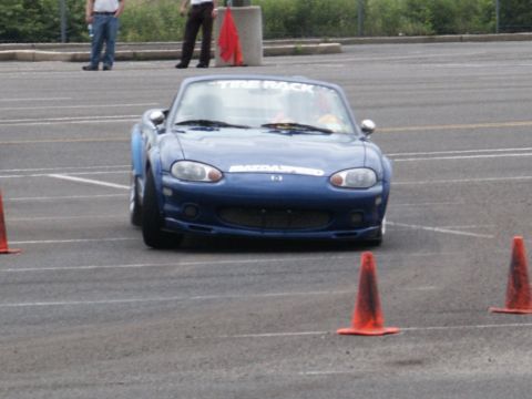2001 Mercury Grand Marquis - A blue Mazda Miata navigates a course marked by orange traffic cones.