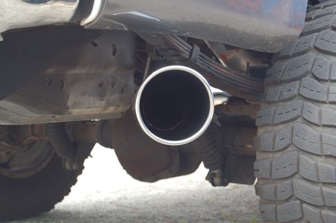 2001 Ford Excursion - The underside of a vehicle shows a large exhaust pipe and a tire tread.
