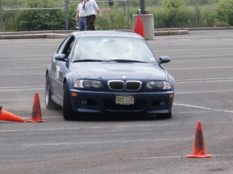 2001 Mercury Grand Marquis - A blue BMW coupe navigates a course marked by orange traffic cones on a paved surface.