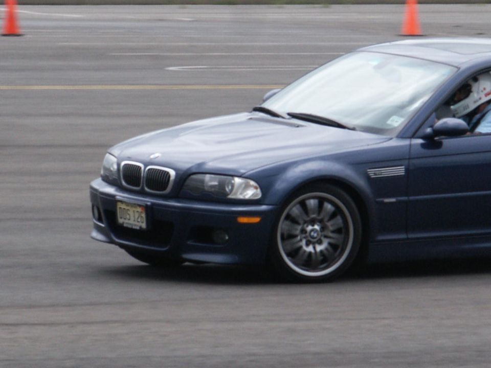 Blue BMW M3 on track, front quarter view. License plate reads DDS 126