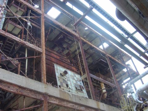 1987 Suzuki Samurai - An abandoned industrial structure shows signs of decay with extensive rust and shattered glass.