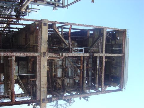 1987 Suzuki Samurai - This photo shows the interior of a large, heavily rusted industrial structure with exposed beams and piping.