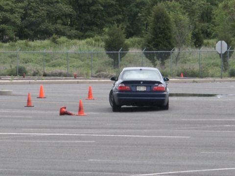 2001 Mercury Grand Marquis - A dark blue sedan navigates a course marked by orange traffic cones in a parking lot.
