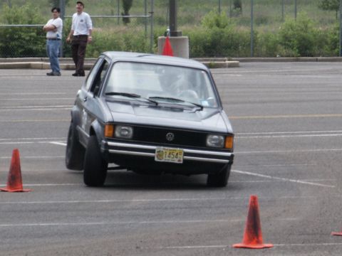2001 Mercury Grand Marquis - Gray Volkswagen Rabbit GTI is seen on a track, maneuvering around orange cones during an event.