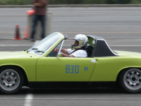 2001 Mercury Grand Marquis - Driver in helmet races a lime green convertible sports car with blue numbers on the door.