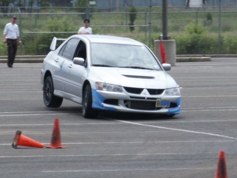 2001 Mercury Grand Marquis - A silver sedan with distinctive blue accents on its front bumper maneuvers through a course marked by traffic cones.