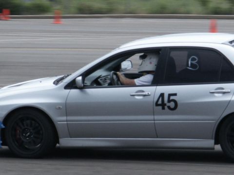 2001 Mercury Grand Marquis - A silver sedan with racing number 45 is seen on a track, driven by a person in a helmet.