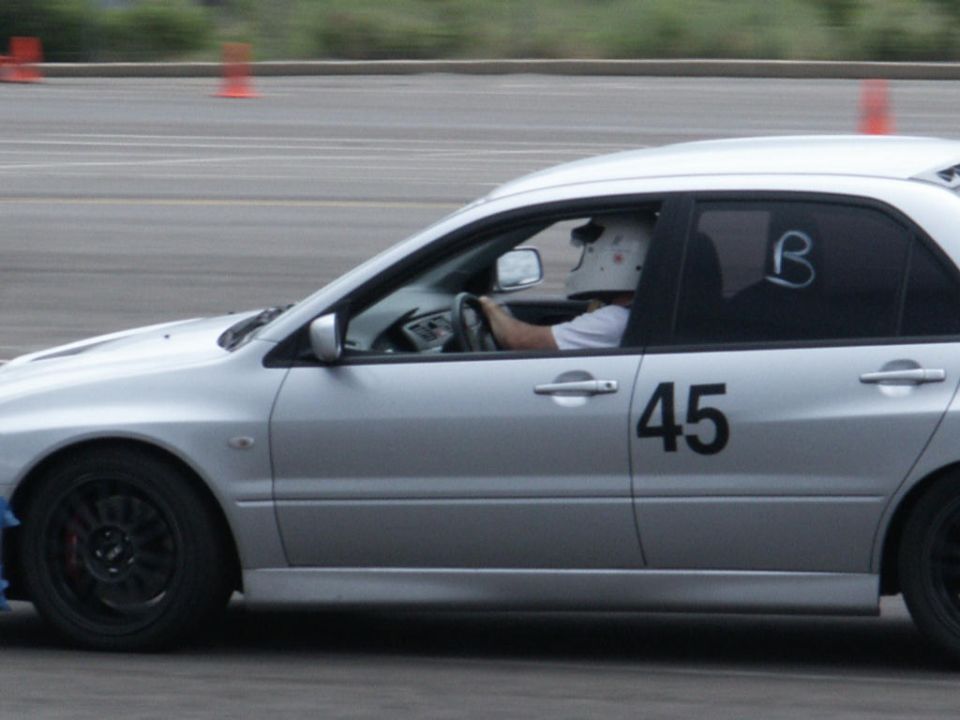 Silver sedan with racing number 45 on the door, driver wearing a helmet