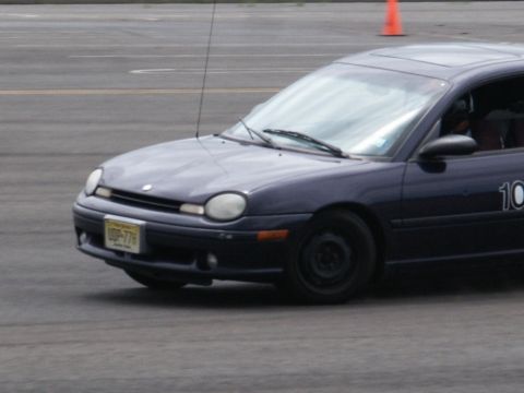 2001 Mercury Grand Marquis - A dark blue Dodge Neon is seen on a track, displaying the number 10 on its side.