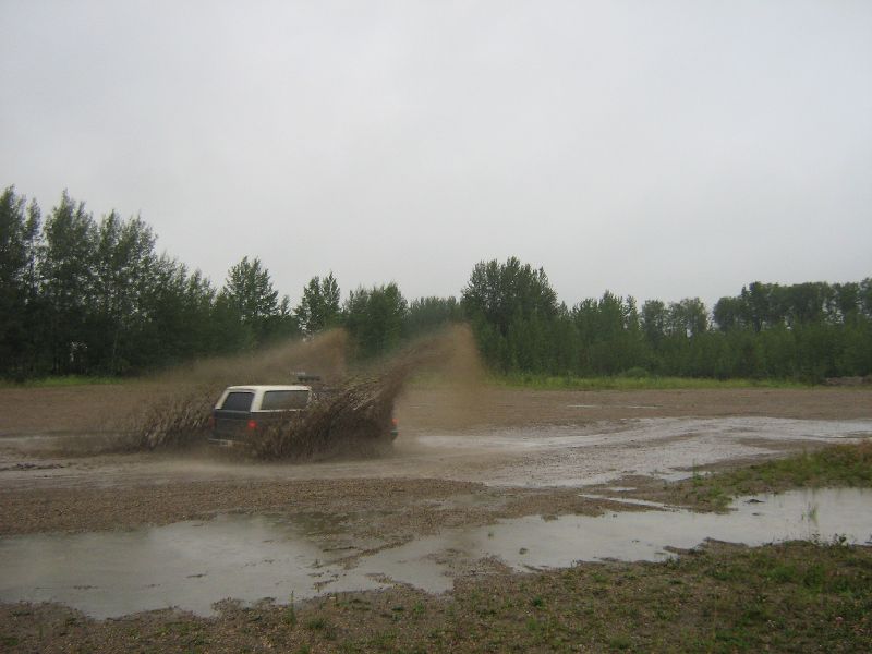 White and brown SUV kicking up mud, 1995 Ford Bronco