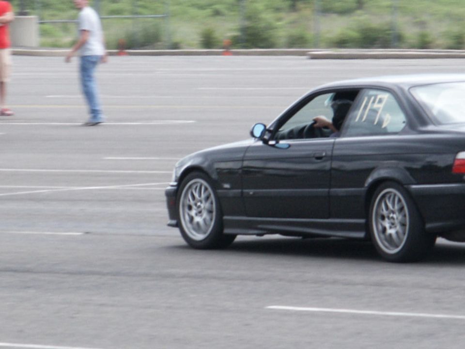 Black coupe with racing number 119 on the window, seen from the side