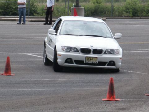 2001 Mercury Grand Marquis - A white BMW sedan navigates a course marked by orange cones on an asphalt surface.
