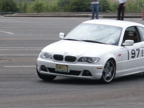 2001 Mercury Grand Marquis - A white BMW 3 Series E46 is seen on a race track with racing numbers displayed on its side.