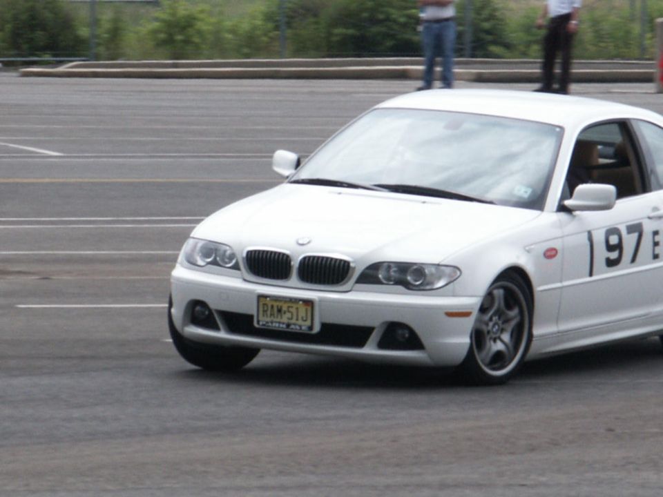 White BMW 3 Series E46 with racing numbers on the door, on a track