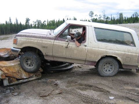 1995 Ford Bronco - This 1995 Ford Bronco is seen stuck on rocks and mud, with its driver looking out the window.
