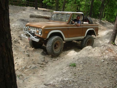 1995 Ford Bronco - A driver navigates a challenging off-road path in a classic Ford Bronco.