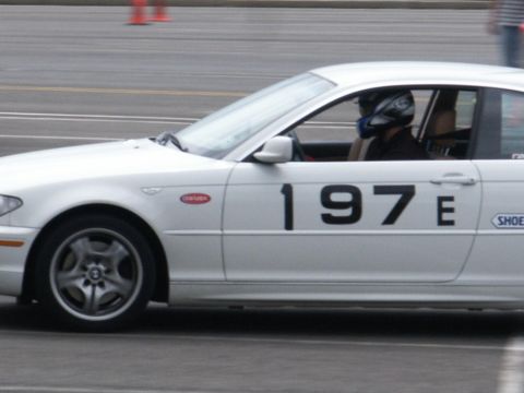 2001 Mercury Grand Marquis - A white race car, identified by the number 197E on its side, is captured in a side profile view with a helmeted driver inside.
