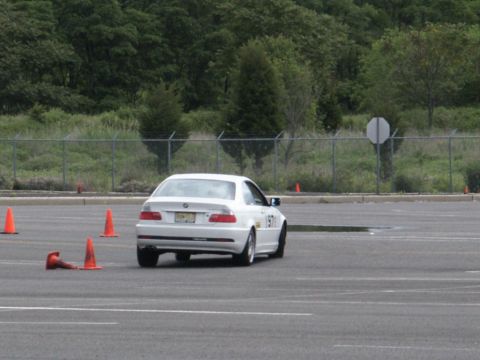 2001 Mercury Grand Marquis - A white BMW sedan navigates a course marked by orange cones on a paved track.