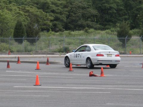 2001 Mercury Grand Marquis - A white coupe navigates a course marked by orange traffic cones on a paved lot.