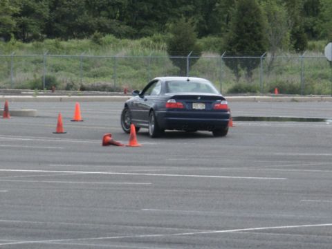 2001 Mercury Grand Marquis - A dark blue coupe navigates a course marked by orange traffic cones on a paved surface.
