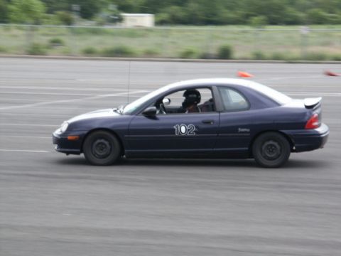 2001 Mercury Grand Marquis - A dark blue coupe, identified by racing number 102, is captured in profile on a race track.