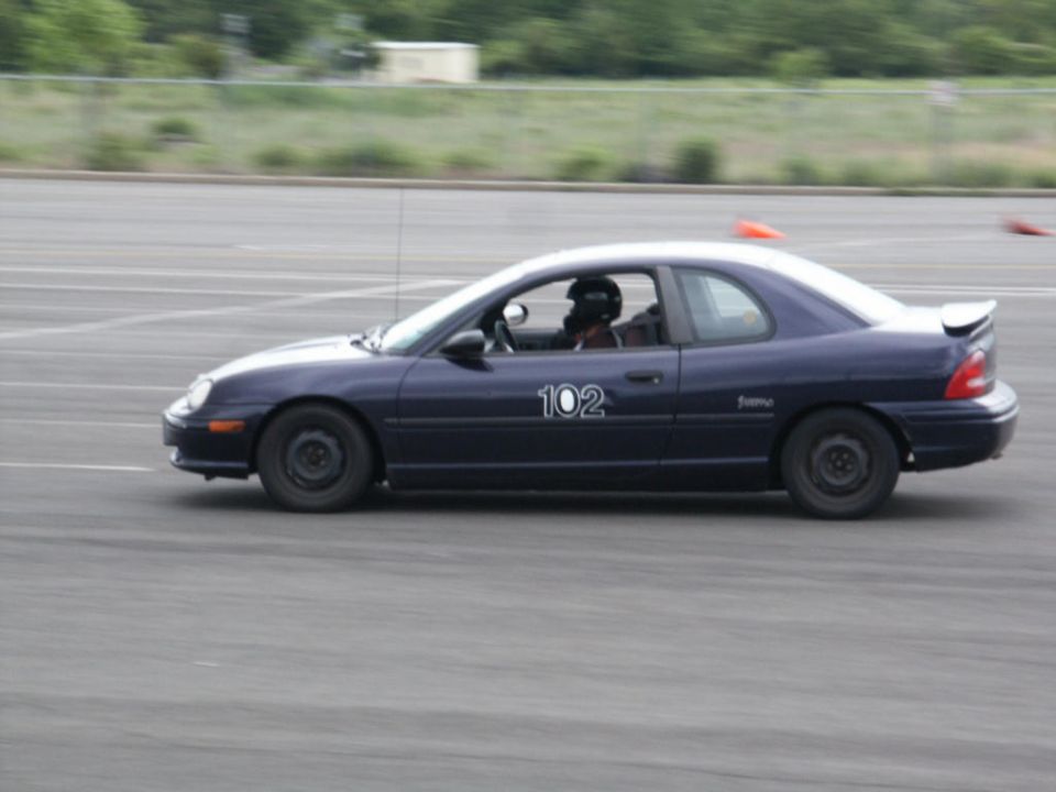 Dark blue coupe with racing number 102 on the door, seen from the side