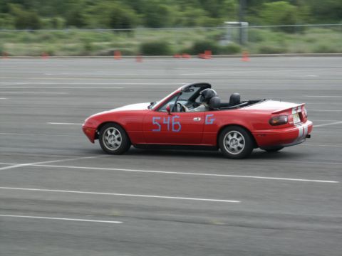 2001 Mercury Grand Marquis - Red convertible sports car with racing numbers on the door drives on a track.