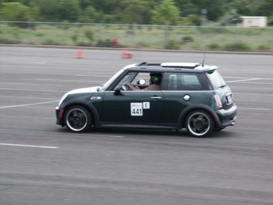 Dark green Mini Cooper with white roof and racing number 441 on the door, seen from the side