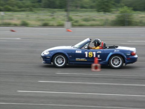 2001 Mercury Grand Marquis - A blue convertible sports car navigates a race track, marked with the number 181E.