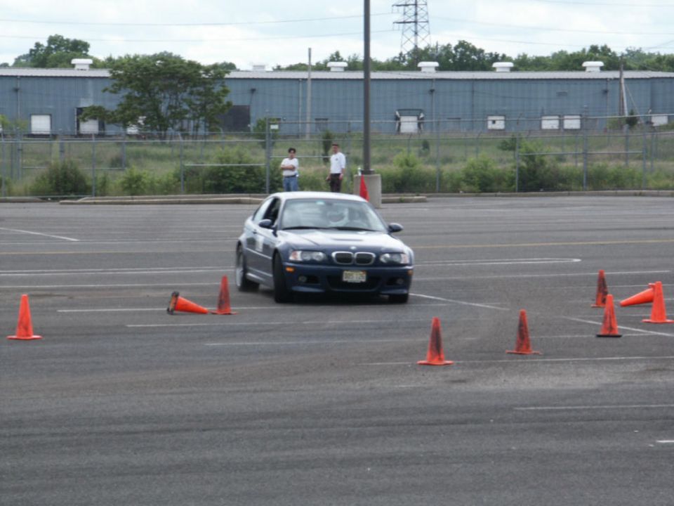 Blue BMW M3 driving through cones in a parking lot. License plate visible