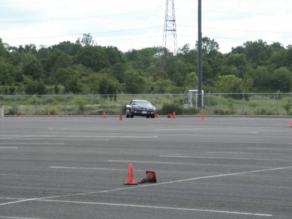 Dark sports car navigating a cone course