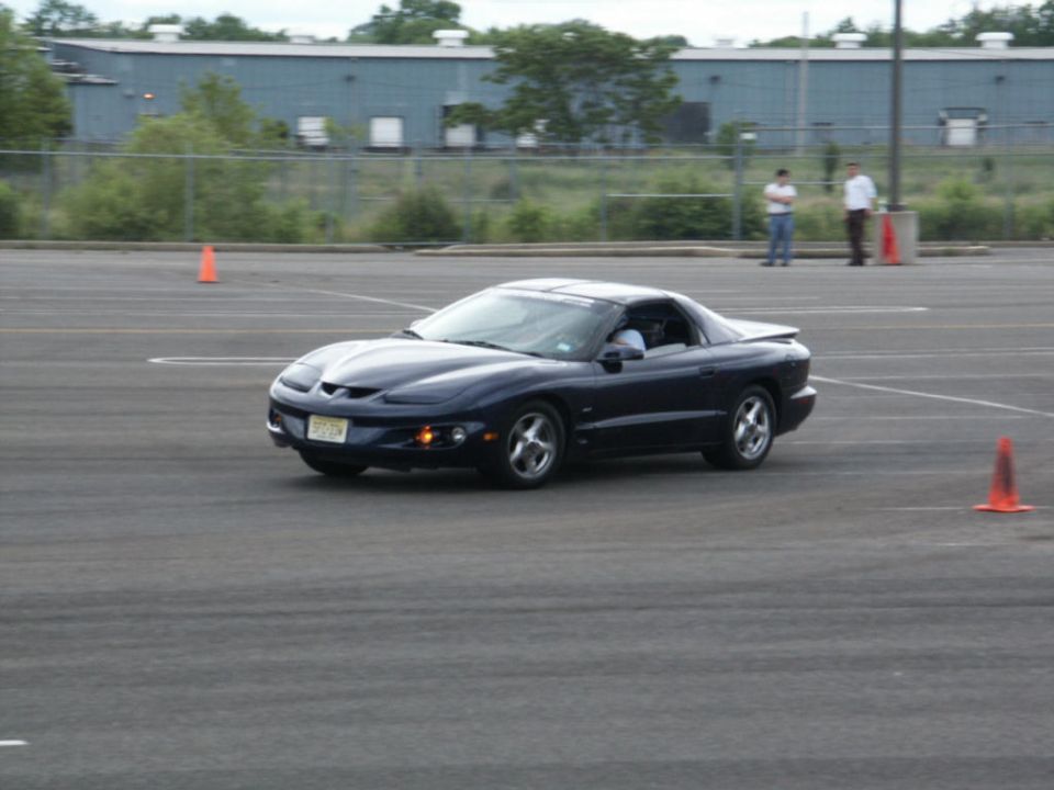 Dark blue coupe with a spoiler, seen from the front-right at an auto-cross event