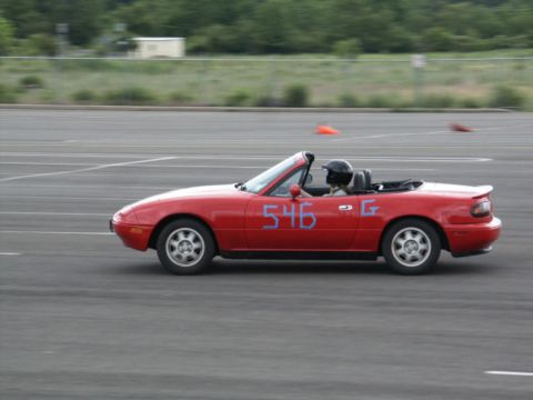 2001 Mercury Grand Marquis - A red convertible sports car with racing numbers is driven on a paved track.