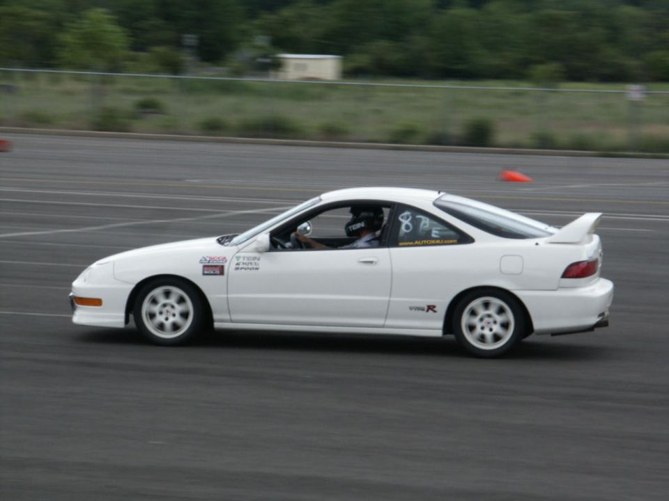 White coupe with racing decals and spoiler on track