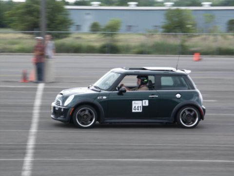 2001 Mercury Grand Marquis - Mini Cooper participating in a track event, driver is wearing a helmet and racing gear.
