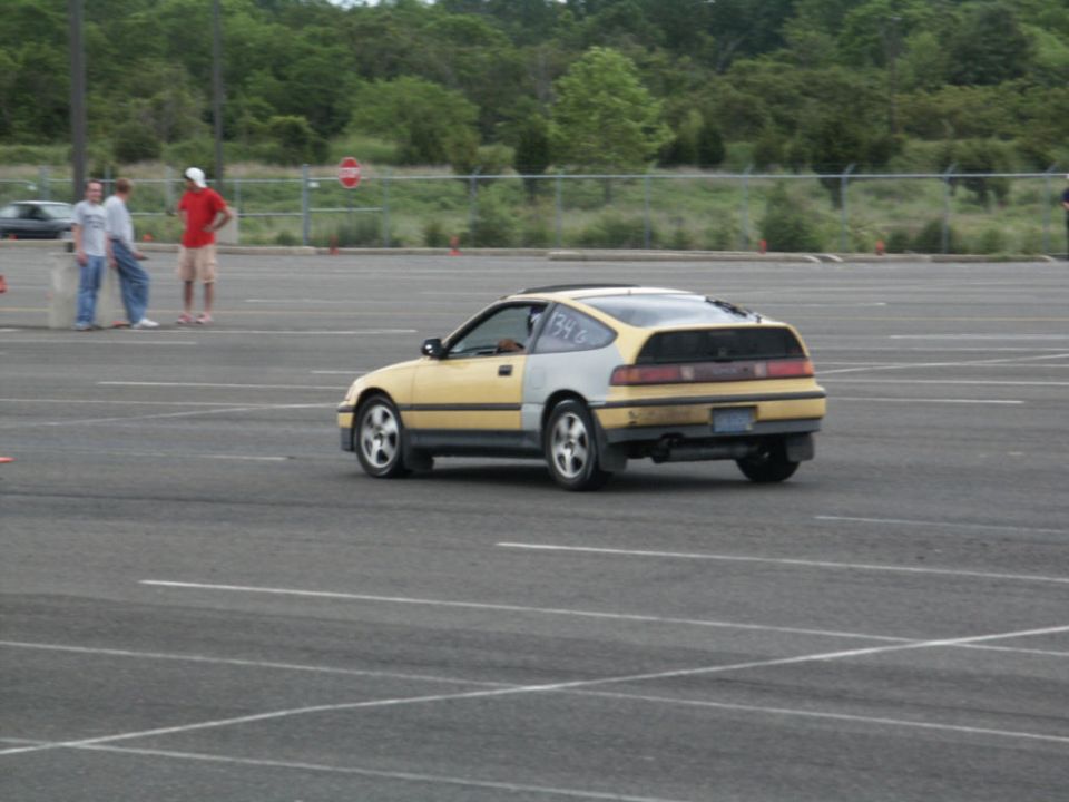 Yellow and grey Honda CRX with racing numbers on the rear quarter panel
