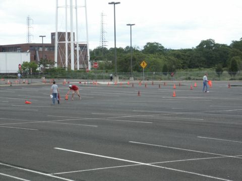2001 Mercury Grand Marquis - People are seen arranging traffic cones in a large, empty parking lot under an overcast sky.
