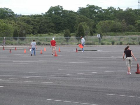 2001 Mercury Grand Marquis - People are arranging traffic cones in an empty parking lot, possibly for a driving course.