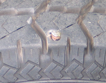 1994 Ford Bronco - Tire tread shows a nail causing a puncture.