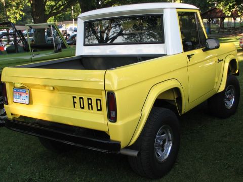 1994 Ford Bronco - This classic Ford Bronco is parked on grass with trees in the background.