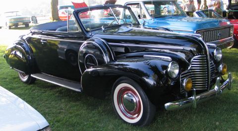 1994 Ford Bronco - A classic black Buick convertible with distinctive whitewall tires is displayed at a car show.
