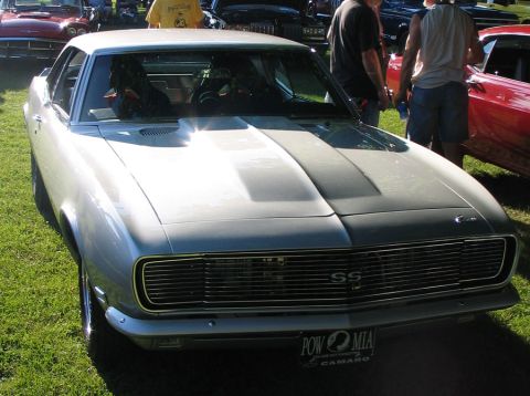 1994 Ford Bronco - A silver 1968 Chevrolet Camaro SS is parked on grass at an outdoor car show.