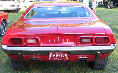 1994 Ford Bronco - Rear view of a red Dodge car with a 1971 Michigan license plate, parked on grass at a car show.