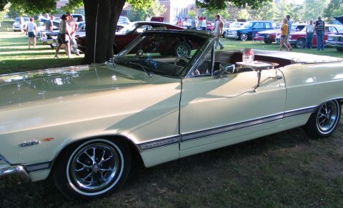 1994 Ford Bronco - Cream 1966 Ford Fairlane convertible at a car show with other vehicles present.
